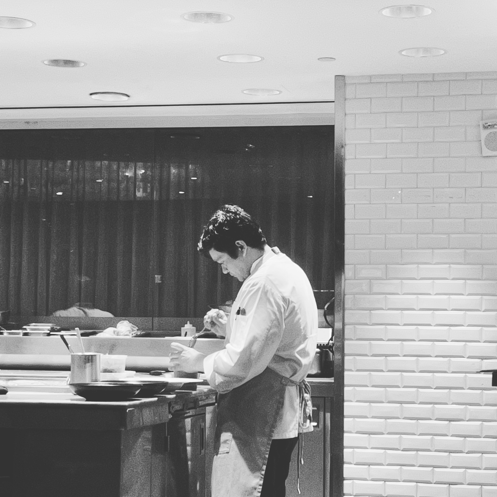 Rodrigo at the kitchen pass in chef whites, plating service